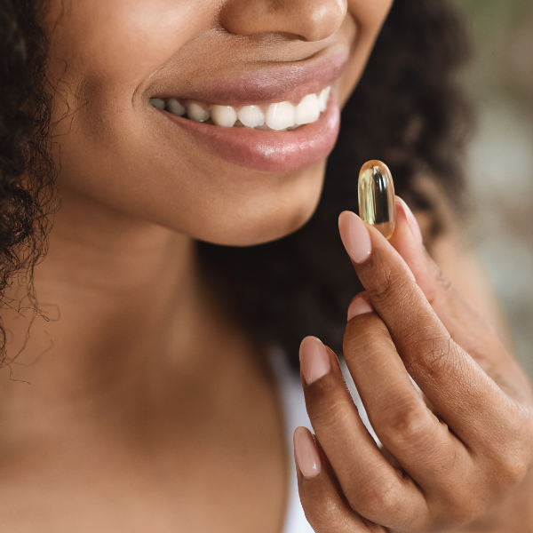 Woman taking omega 3 supplement for perimenopause