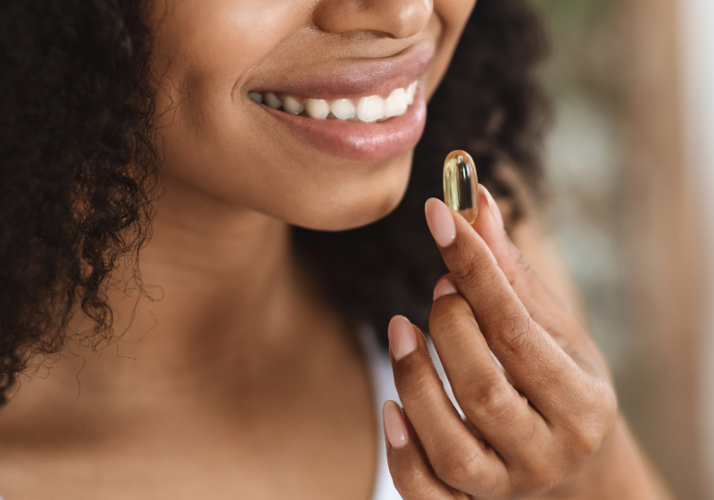 Woman taking omega 3 supplement for perimenopause