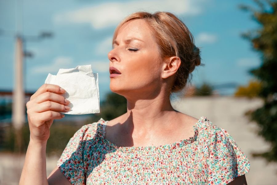 what causes hot flashes in perimenopause? Woman with sweating and hot flash